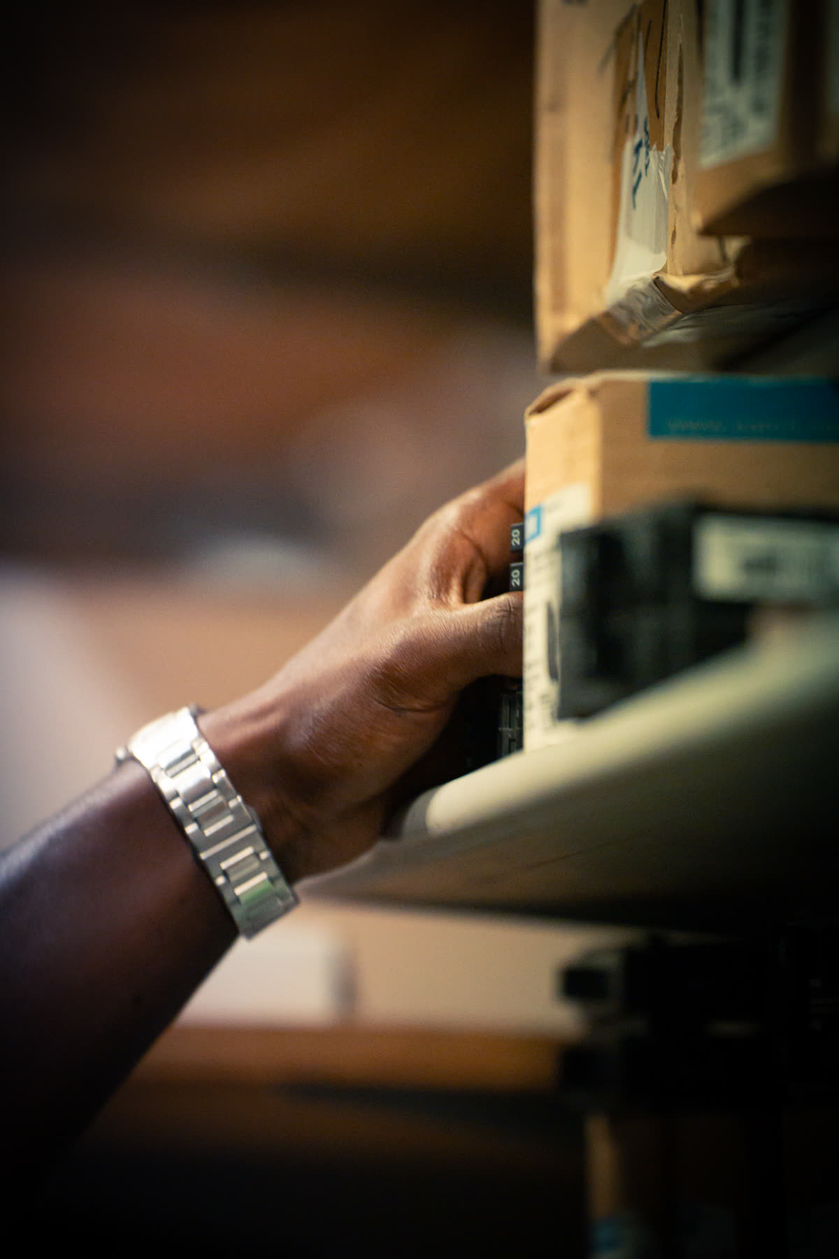 Close-up of a technician's hand working at an electrical panel